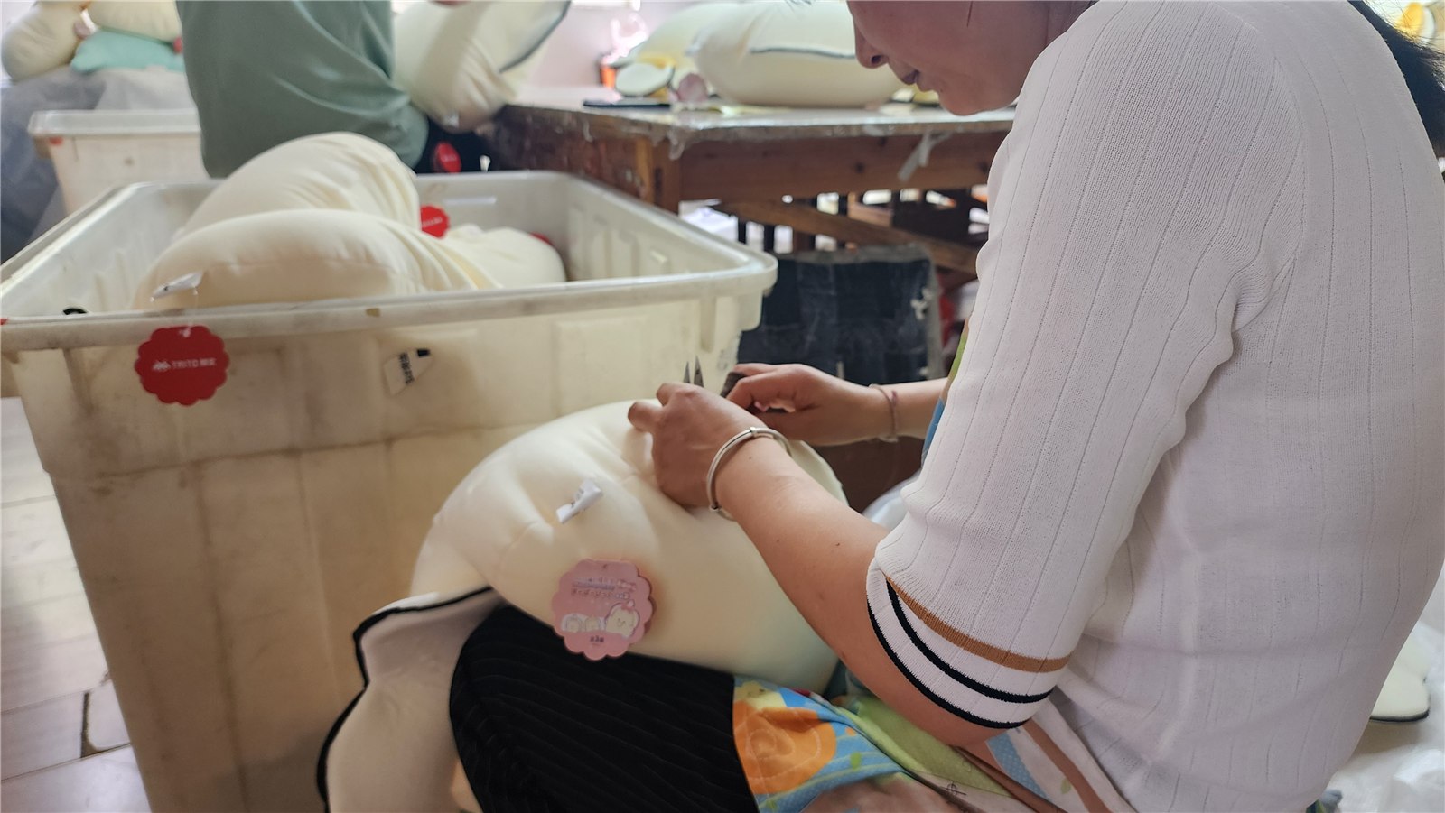 Hand finishing a plush toy in the workshop