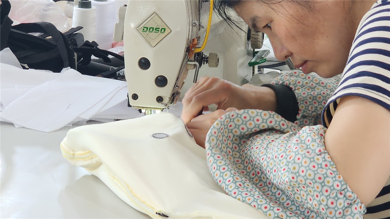 Close-up of plush pieces being stitched at a sewing machine
